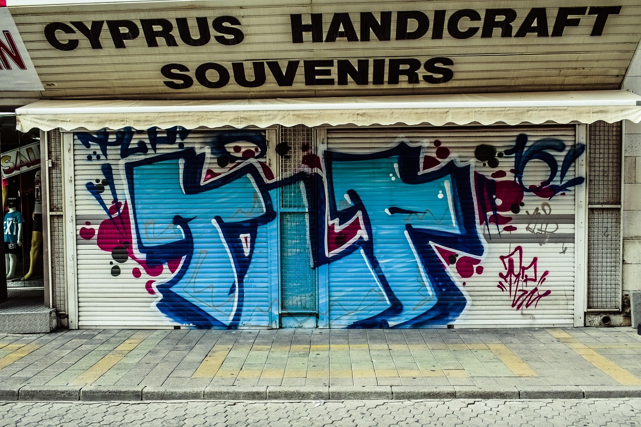 Geschlossener Ladenrollladen mit Graffiti und englischer Beschriftung in Limassol